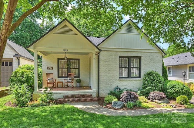 2015 Club Rd, Charlotte, NC 28205 - view of front facade featuring a porch, brick siding, a front yard, and a garage