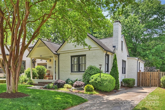 2015 Club Rd, Charlotte, NC 28205 - view of front of home with a front lawn, fence, a chimney, brick siding, and a shingled roof