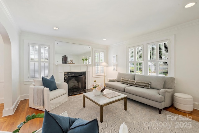 2015 Club Rd, Charlotte, NC 28205 - living room featuring crown molding, arched walkways, a high end fireplace, and wood finished floors