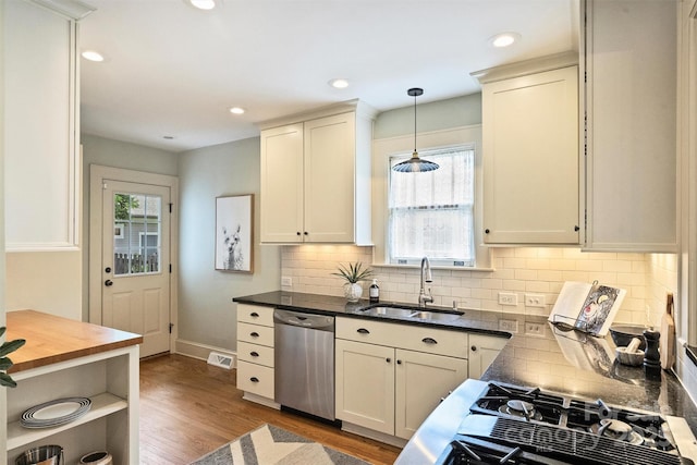 2015 Club Rd, Charlotte, NC 28205 - kitchen featuring backsplash, hanging light fixtures, stainless steel dishwasher, wood finished floors, and a sink