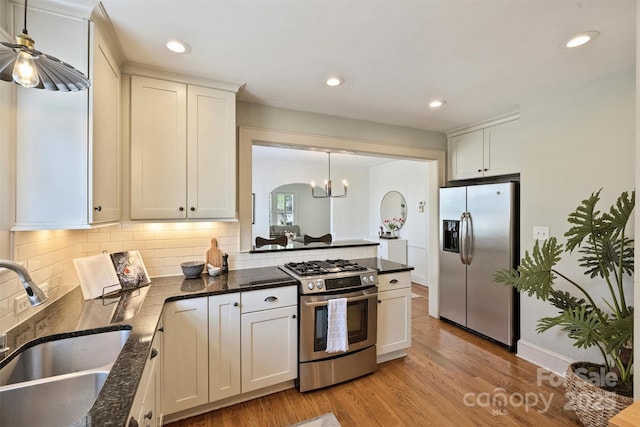 2015 Club Rd, Charlotte, NC 28205 - kitchen with appliances with stainless steel finishes, tasteful backsplash, light wood-type flooring, a sink, and white cabinetry