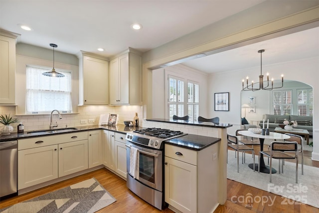 2015 Club Rd, Charlotte, NC 28205 - kitchen featuring a peninsula, tasteful backsplash, a sink, a notable chandelier, and stainless steel appliances