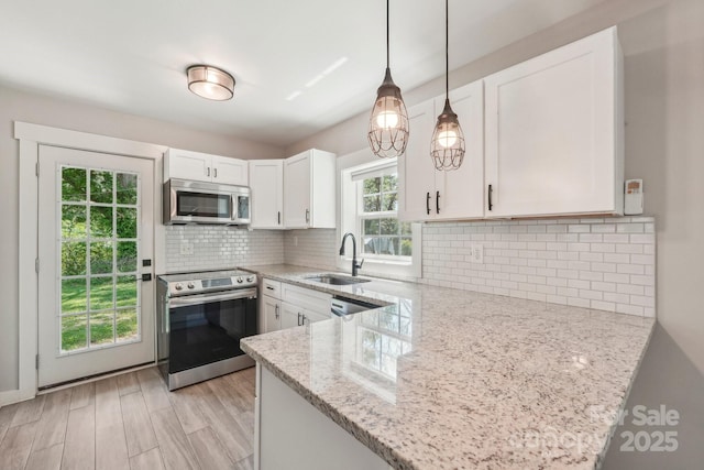 814 Marve St, Gastonia, NC 28052 - kitchen with white cabinetry, light stone counters, a sink, decorative light fixtures, and stainless steel appliances