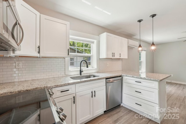 814 Marve St, Gastonia, NC 28052 - kitchen featuring white cabinets, appliances with stainless steel finishes, a sink, a peninsula, and a wall unit AC