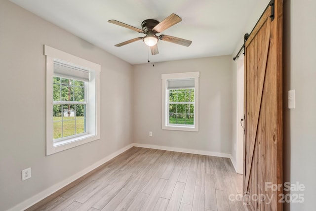 814 Marve St, Gastonia, NC 28052 - unfurnished bedroom with multiple windows, light wood-type flooring, and a barn door