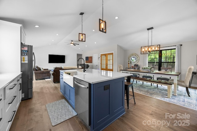 17403 Green Hill Rd, Charlotte, NC 28278 - kitchen with a sink, appliances with stainless steel finishes, blue cabinetry, vaulted ceiling, and a chandelier