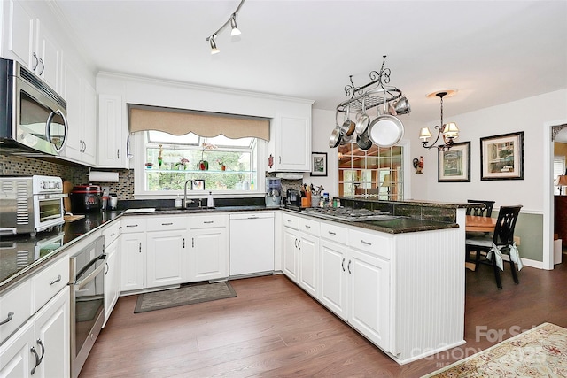10209 Thomas Payne Cir, Charlotte, NC 28277 - kitchen with a sink, a chandelier, stainless steel appliances, a peninsula, and backsplash