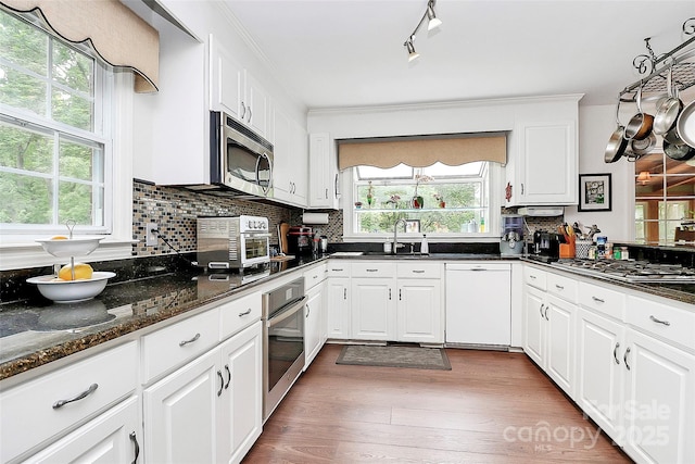 10209 Thomas Payne Cir, Charlotte, NC 28277 - kitchen featuring a sink, decorative backsplash, stainless steel appliances, and white cabinets