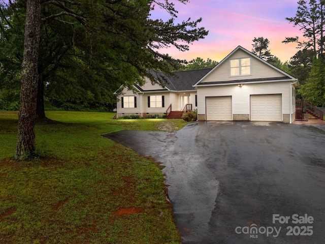 view of front of property with driveway, a front lawn, and an attached garage