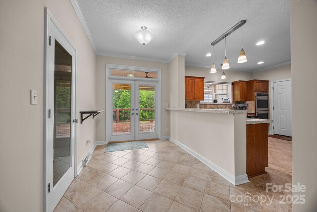 kitchen with plenty of natural light, brown cabinets, french doors, double oven, and a textured ceiling