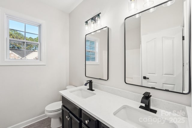 5745 Snapdragon Ln, Huntersville, NC 28078 - bathroom with double vanity, toilet, baseboards, and a sink