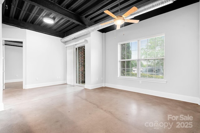 empty room with concrete floors and baseboards