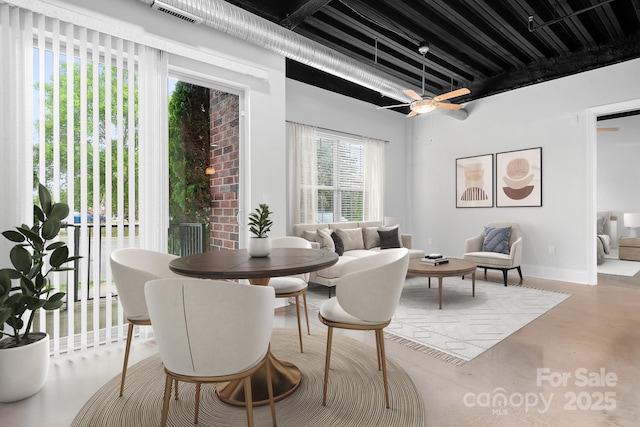 dining area featuring finished concrete floors, baseboards, and a ceiling fan