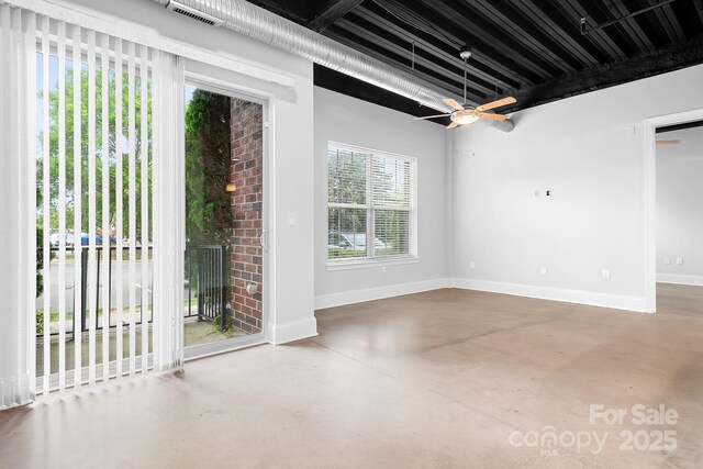 unfurnished living room featuring concrete flooring, baseboards, and ceiling fan