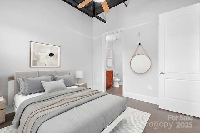 bedroom featuring baseboards, connected bathroom, beam ceiling, and ceiling fan