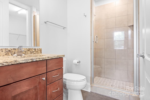 full bathroom featuring a shower stall, toilet, vanity, and tile patterned flooring