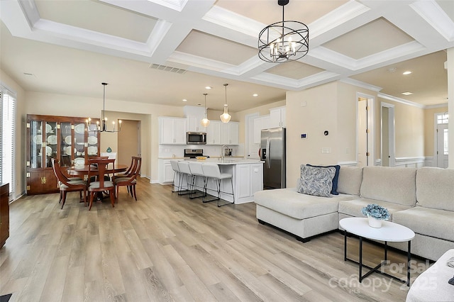 living area with an inviting chandelier, light wood finished floors, recessed lighting, visible vents, and coffered ceiling