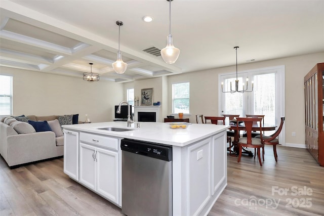 kitchen with stainless steel dishwasher, open floor plan, a notable chandelier, and a sink