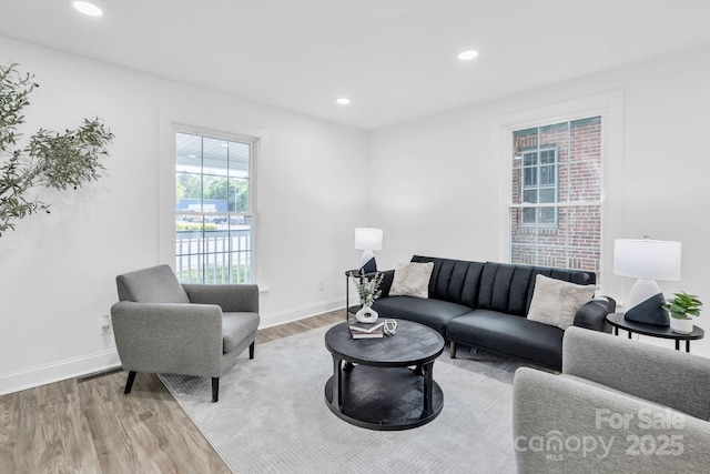 living area featuring recessed lighting, baseboards, and wood finished floors