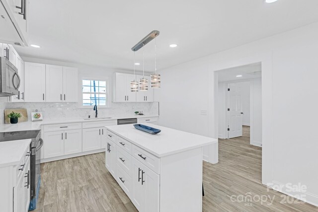 kitchen featuring recessed lighting, stainless steel microwave, a sink, and electric range oven