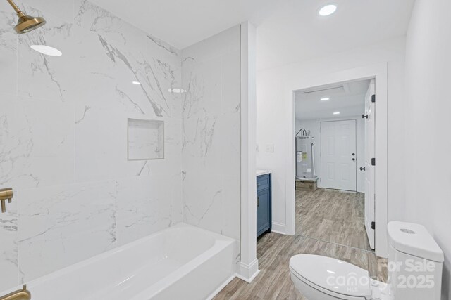 bathroom with wood finished floors, vanity, toilet, recessed lighting, and electric water heater