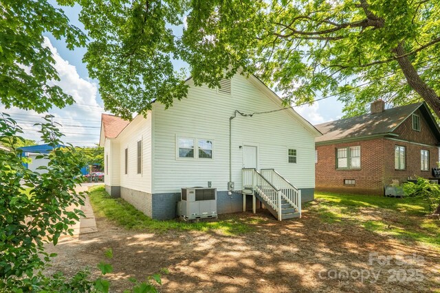 back of house with central AC unit