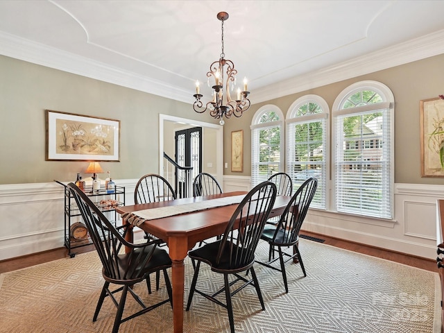 4701 Pineland Pl, Charlotte, NC 28277 - dining area featuring light wood finished floors, crown molding, wainscoting, and a notable chandelier