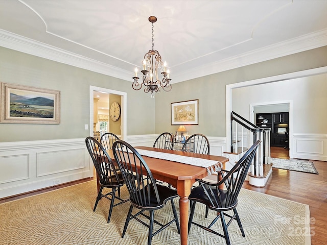 4701 Pineland Pl, Charlotte, NC 28277 - dining area featuring a wainscoted wall, wood finished floors, ornamental molding, and a notable chandelier