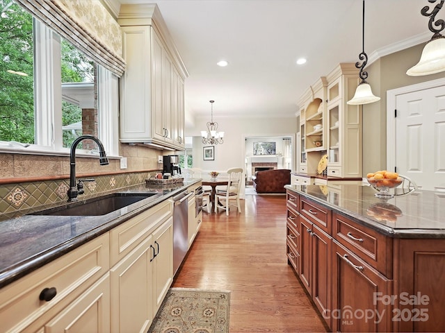4701 Pineland Pl, Charlotte, NC 28277 - kitchen with stainless steel dishwasher, a sink, crown molding, decorative backsplash, and dark stone counters