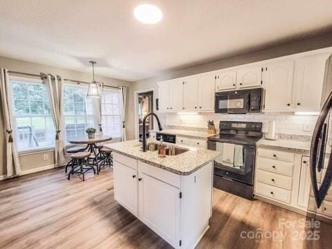 6231 Kentwood Dr, Kannapolis, NC 28081 - kitchen featuring black appliances, white cabinets, light wood-style flooring, and decorative backsplash