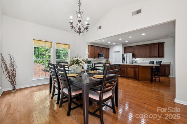 dining room featuring a notable chandelier, visible vents, and light wood-style flooring