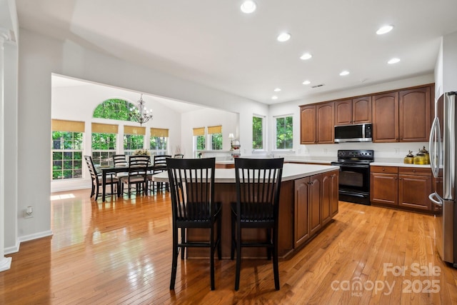 109 Braxton Gate Ct, Mount Holly, NC 28120 - kitchen featuring appliances with stainless steel finishes, a kitchen island, light countertops, recessed lighting, and light wood-style floors