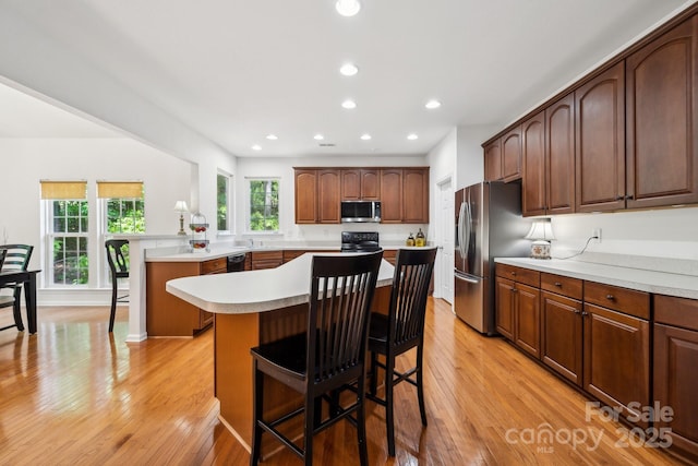 109 Braxton Gate Ct, Mount Holly, NC 28120 - kitchen featuring black appliances, light wood-style floors, light countertops, a center island, and recessed lighting