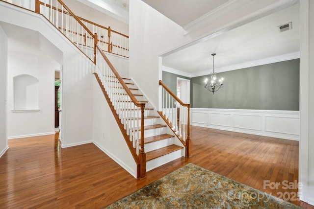 109 Braxton Gate Ct, Mount Holly, NC 28120 - stairway with wood finished floors, crown molding, a chandelier, and a wainscoted wall
