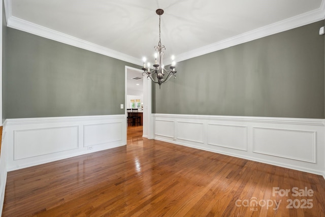 109 Braxton Gate Ct, Mount Holly, NC 28120 - unfurnished dining area featuring a chandelier, crown molding, wood finished floors, and a wainscoted wall
