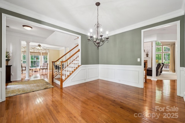 109 Braxton Gate Ct, Mount Holly, NC 28120 - empty room with a chandelier, stairs, wood-type flooring, decorative columns, and wainscoting