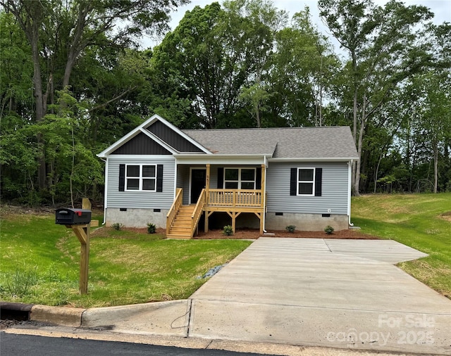 view of front of home with stairs, a shingled roof, a front lawn, crawl space, and covered porch