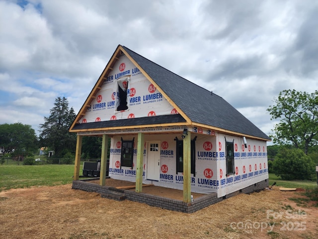 unfinished property featuring a shingled roof