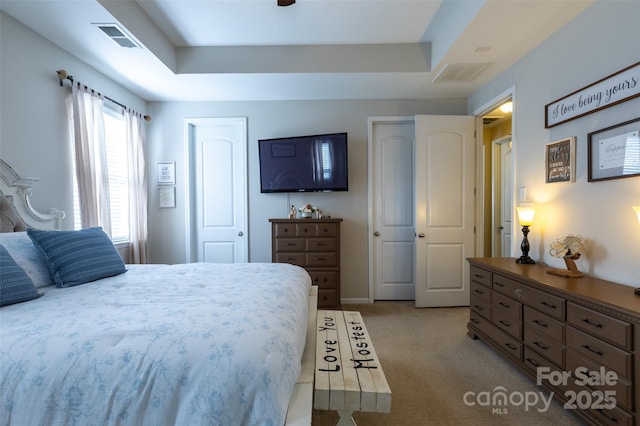 3186 Helmsley Ct, Concord, NC 28027 - bedroom with multiple closets, light carpet, a tray ceiling, and visible vents