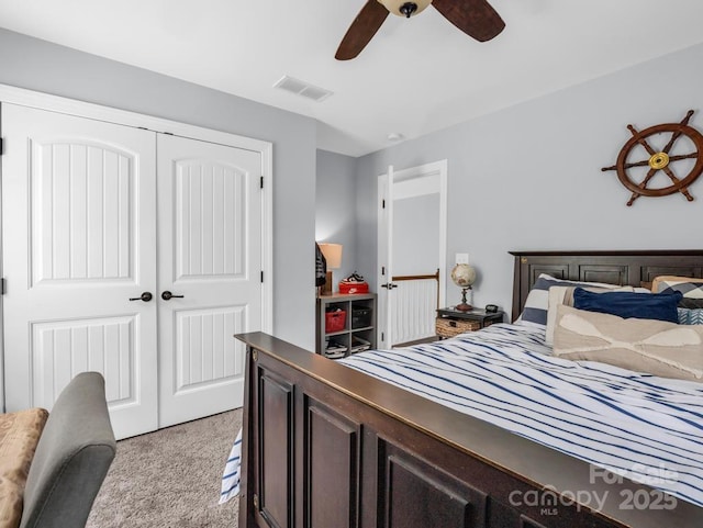 carpeted bedroom with a ceiling fan, visible vents, and a closet