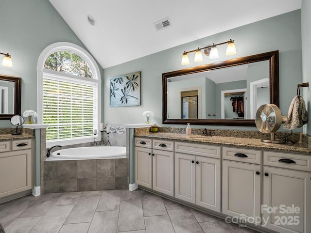 bathroom with a bath, visible vents, tile patterned flooring, vanity, and lofted ceiling