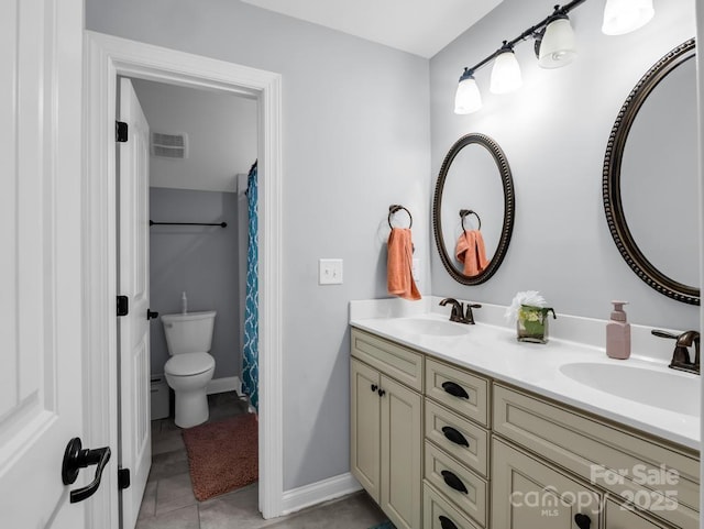 bathroom featuring double vanity, toilet, visible vents, and a sink