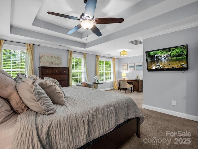 bedroom featuring visible vents, baseboards, a tray ceiling, a ceiling fan, and carpet