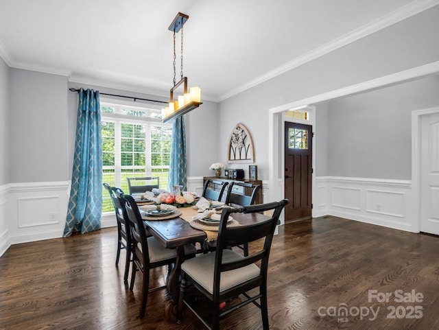 dining area featuring wainscoting, ornamental molding, and a decorative wall