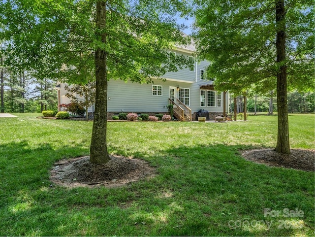 rear view of property with a lawn and entry steps