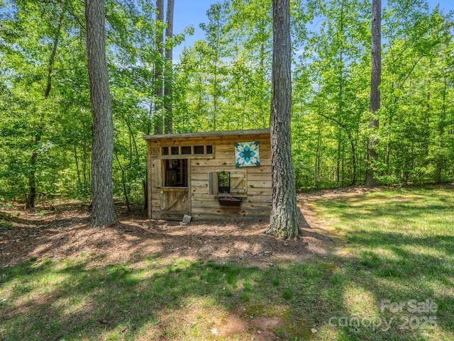 view of outbuilding featuring an outbuilding and a forest view