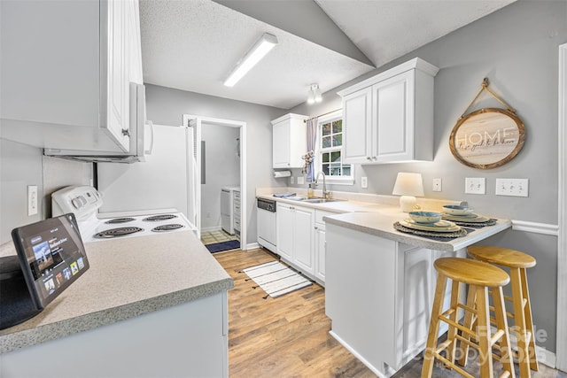 311 Masters Dr, Rock Hill, SC 29732 - kitchen featuring white appliances, a sink, a peninsula, a kitchen bar, and light wood-style flooring