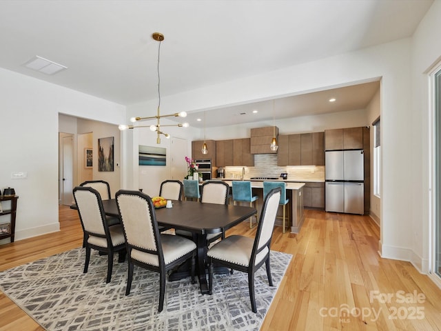 dining space with visible vents, an inviting chandelier, baseboards, light wood-type flooring, and recessed lighting