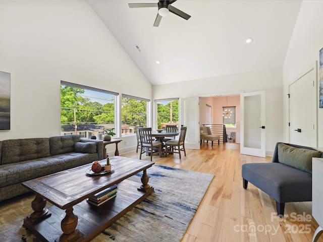 living room featuring visible vents, high vaulted ceiling, recessed lighting, light wood-style flooring, and ceiling fan with notable chandelier