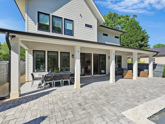 rear view of house featuring fence, a patio, outdoor dining space, and outdoor lounge area